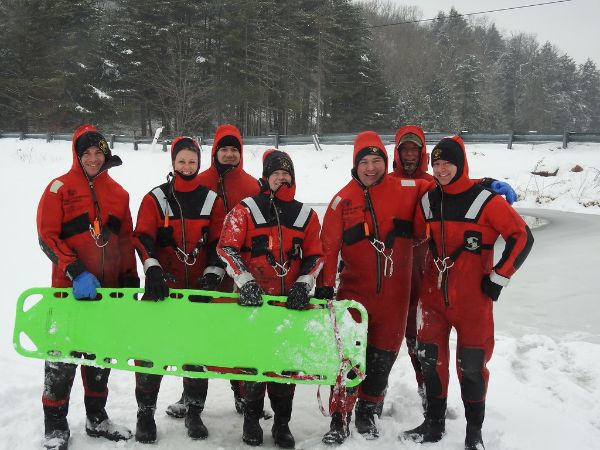 Several officers in winter gear next to a frozen lake