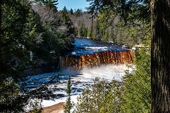 A roaring Upper Tahquamenon Falls is shown in April 2026 heightened by winter snow melt.