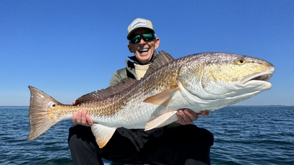 Adult holding large reddrum on vessel