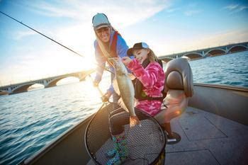 Anglers on a boat hold up a walleye they caught. Photo credit: Pure Michigan