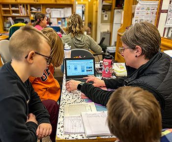 Sarah Roche from MiSTEM helps students create labels for lure packages.