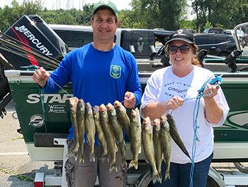 Two anglers show their catch after a successful walleye outing.